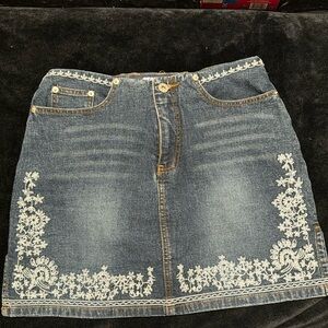 STONE jean mini skirt with brown stitching and baby blue embroidery.Style 05547